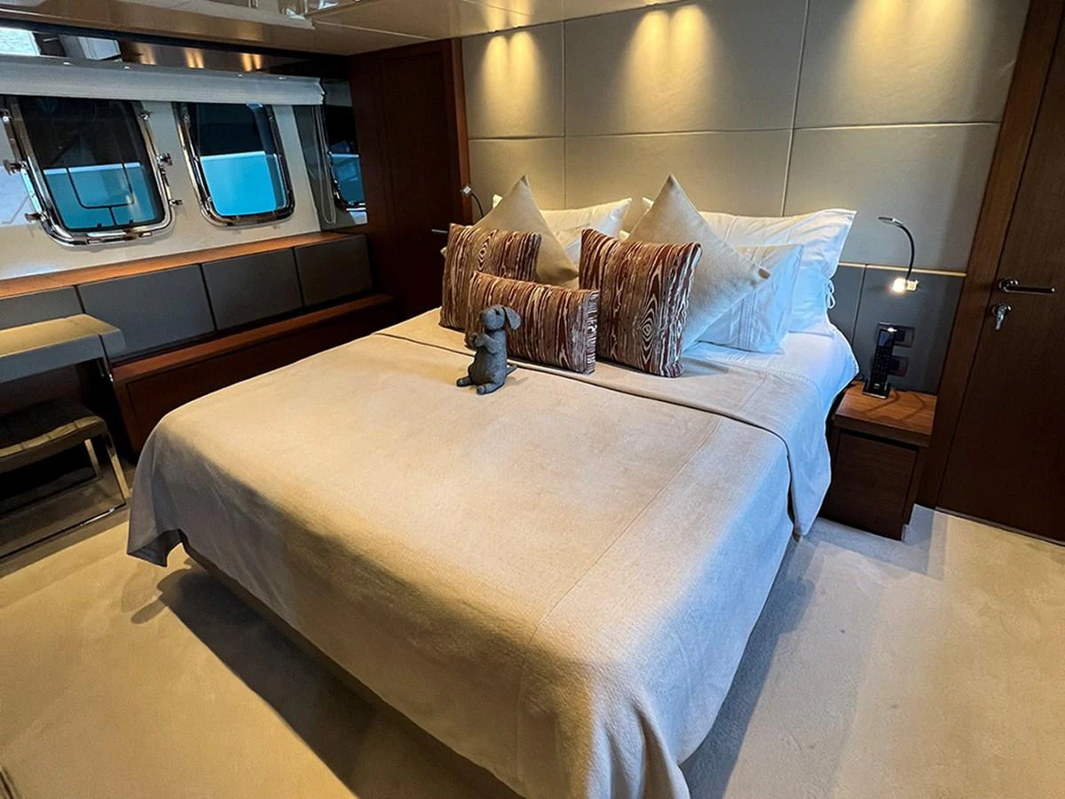 A luxurious stateroom featuring a plush bed with elegant pillows and soft lighting. aboard LA ISLA Yacht for Sale