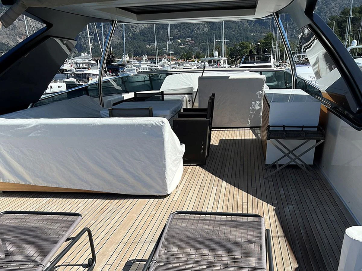 The flybridge offers a spacious and comfortable area for relaxation with covered seating and sun loungers. aboard LA ISLA Yacht for Sale