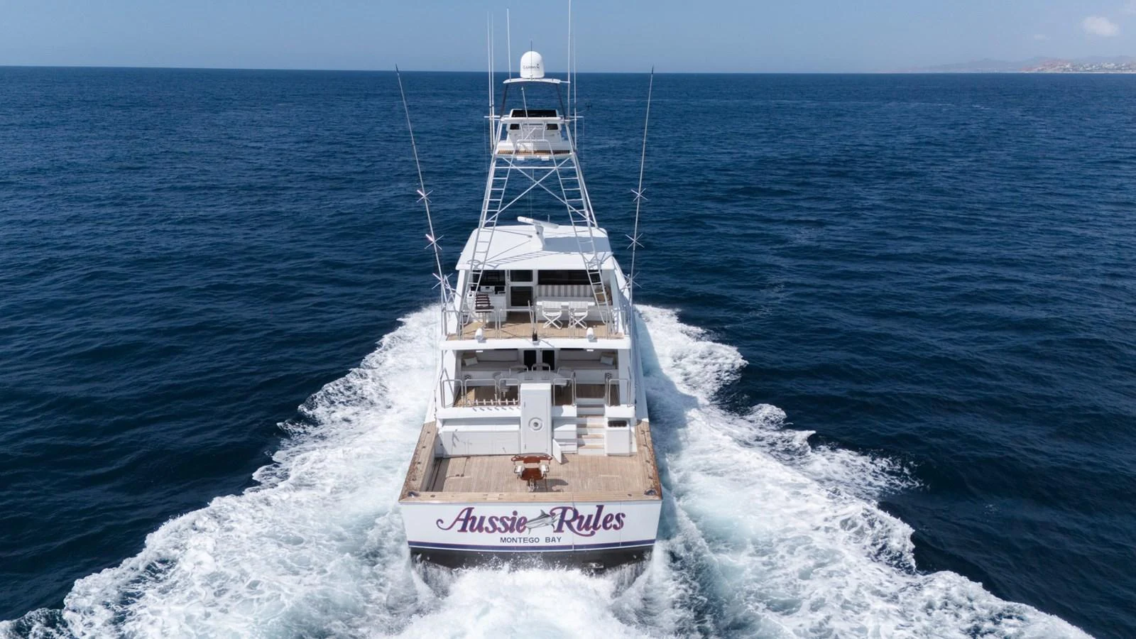 A yacht cruises through the open sea, leaving a trail of white wake behind. aboard AUSSIE RULES Yacht for Sale