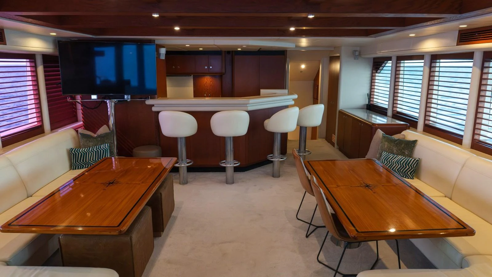 The salon features a cozy seating area with a bar and dining tables, creating a warm and inviting atmosphere. aboard AUSSIE RULES Yacht for Sale