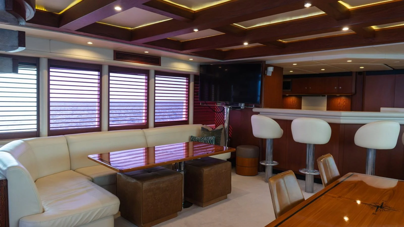 The yacht's interior features a luxurious seating area with a dining table and a bar counter. aboard AUSSIE RULES Yacht for Sale