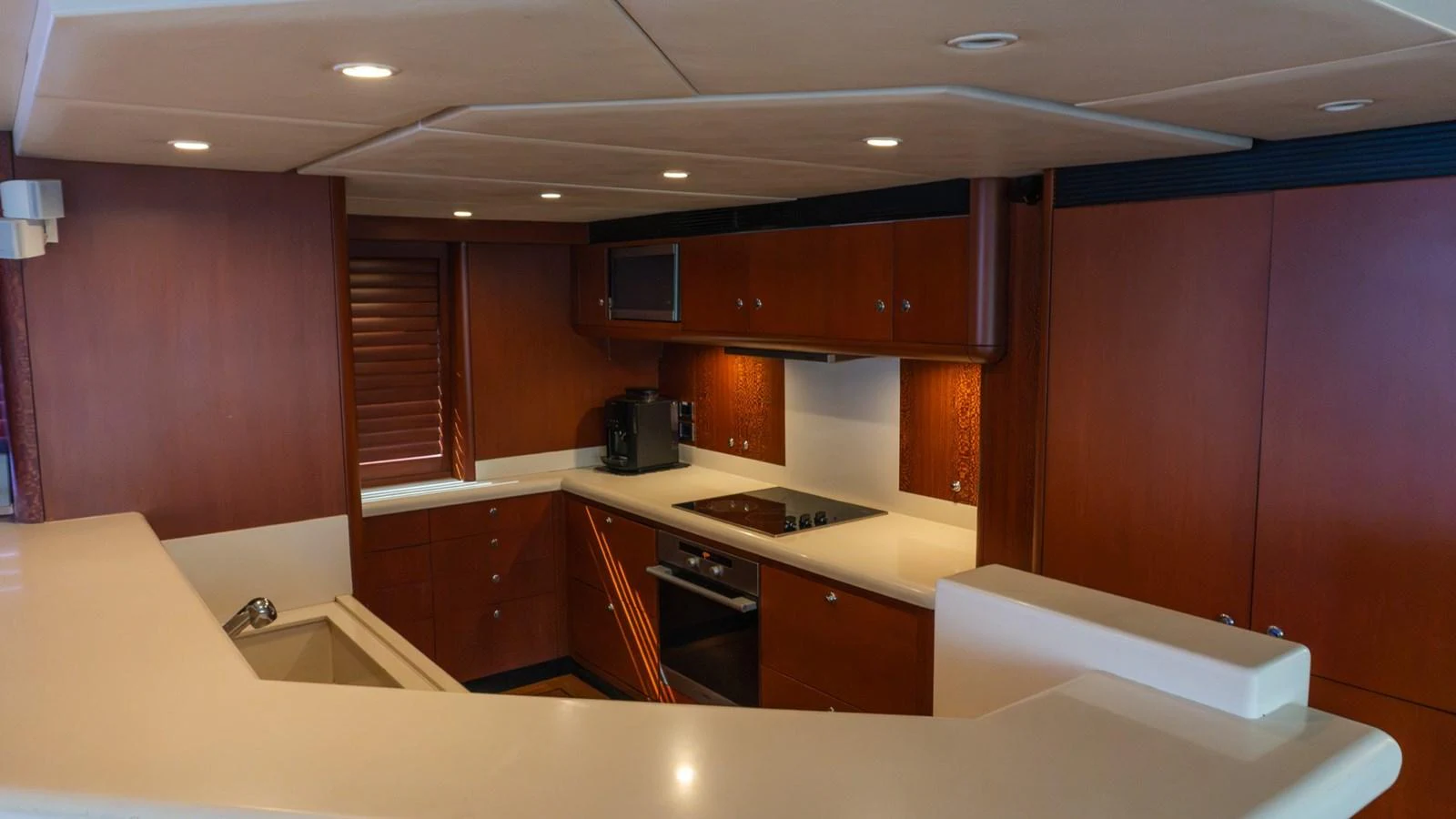 The yacht's galley features modern appliances and a sleek design with rich wood cabinetry. aboard AUSSIE RULES Yacht for Sale