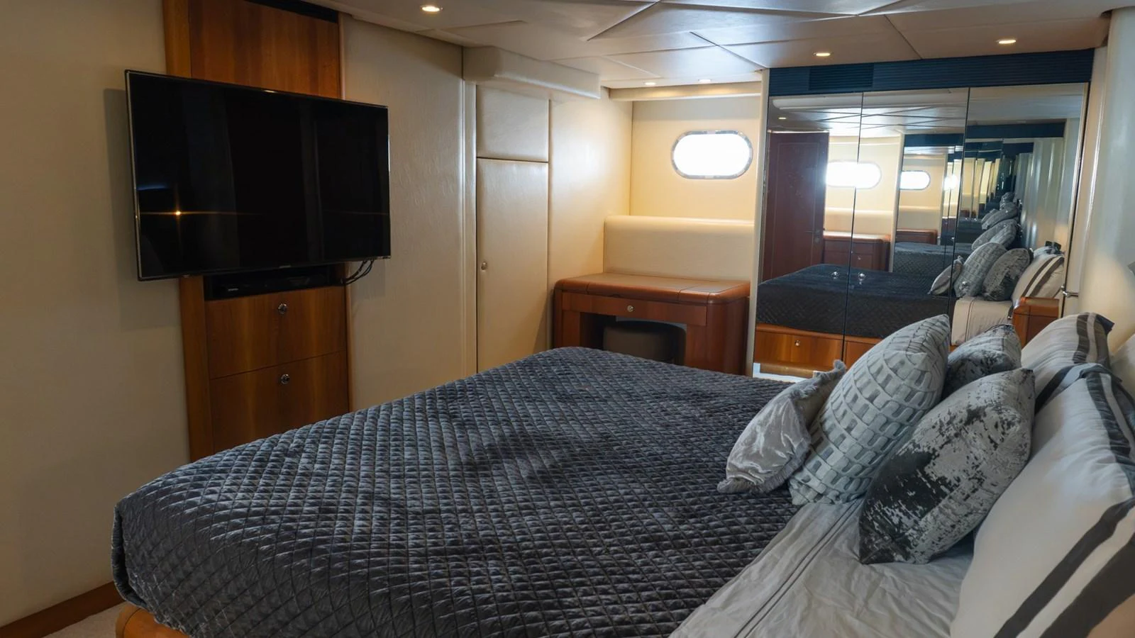 The stateroom features a comfortable bed with elegant bedding and a wall-mounted television. aboard AUSSIE RULES Yacht for Sale