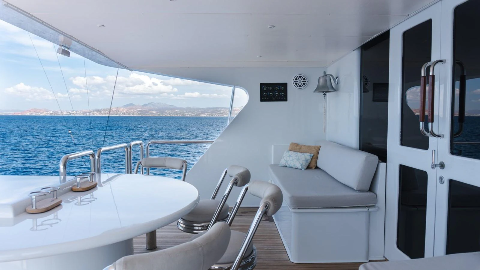 The aft deck features a comfortable seating area with a table, perfect for enjoying the ocean views. aboard AUSSIE RULES Yacht for Sale
