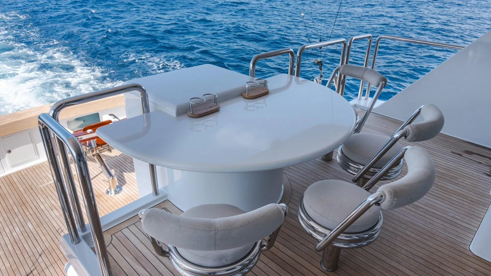 The aft deck features a sleek dining area with a stunning ocean view. aboard AUSSIE RULES Yacht for Sale