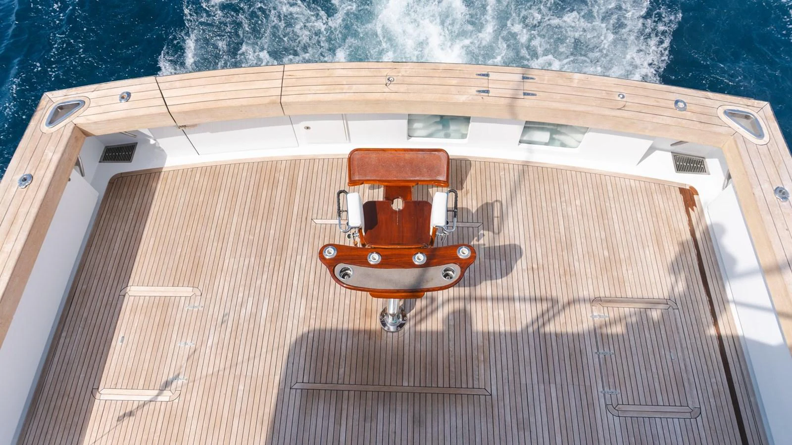 The aft deck features a beautifully crafted wooden fighting chair, perfect for sport fishing enthusiasts. aboard AUSSIE RULES Yacht for Sale