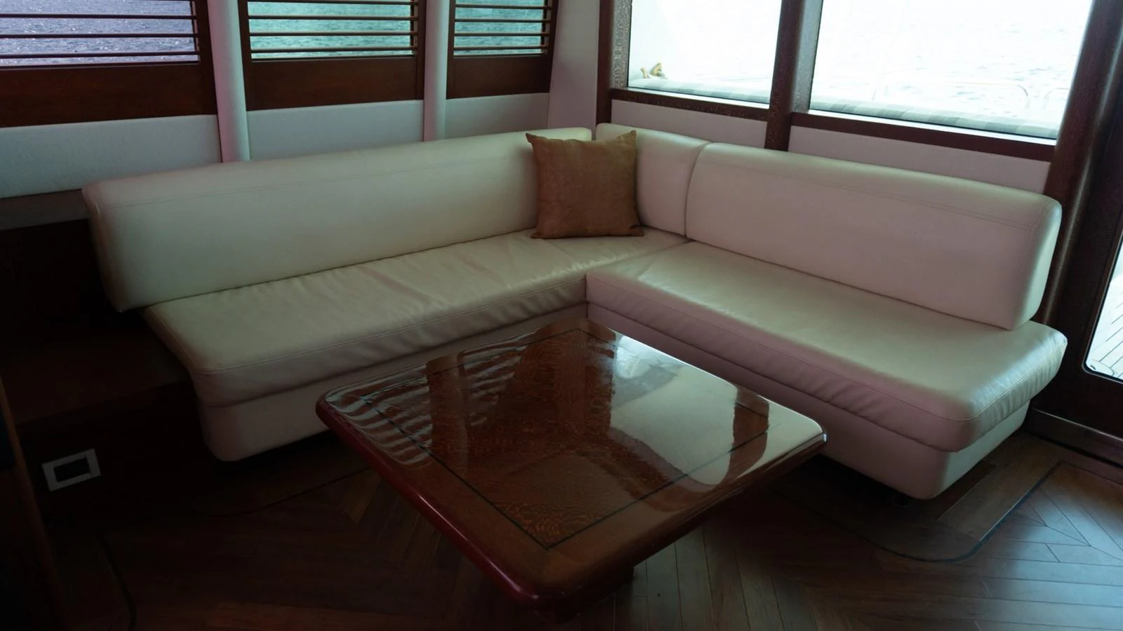 The salon features a comfortable L-shaped sofa with a wooden coffee table. aboard AUSSIE RULES Yacht for Sale
