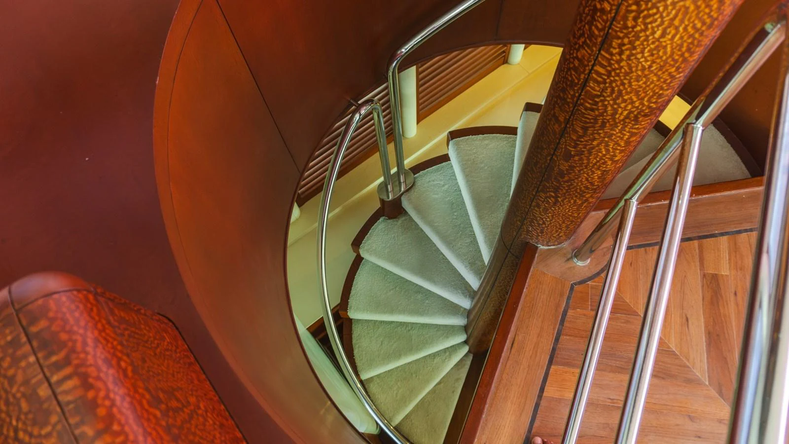 A beautifully crafted spiral staircase with wooden accents and metal railings. aboard AUSSIE RULES Yacht for Sale