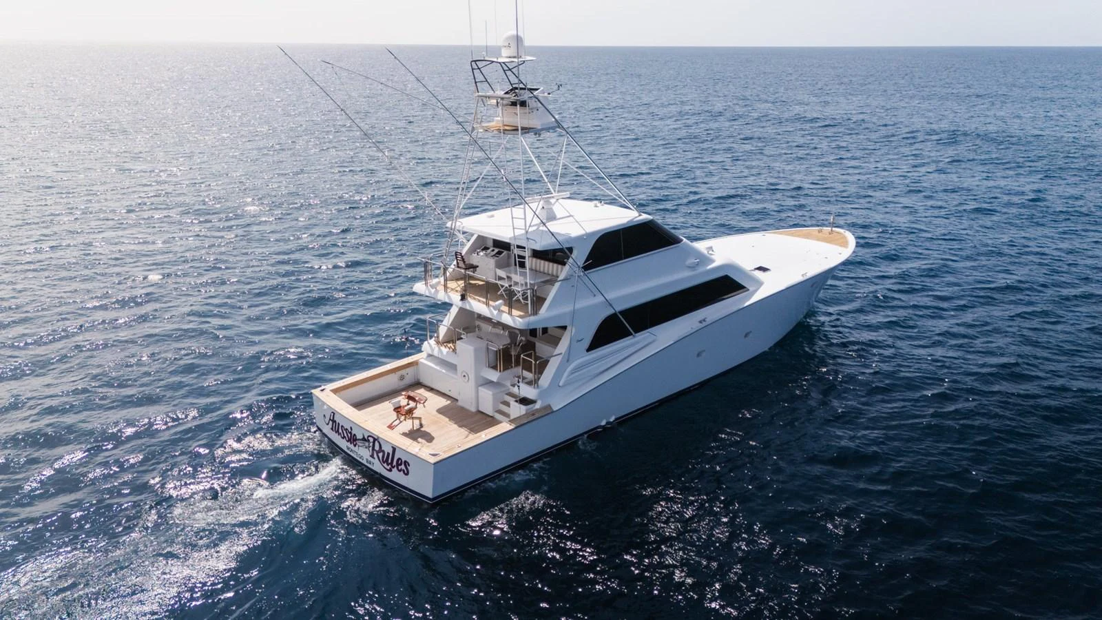 A sleek yacht cruises through calm waters, showcasing its elegant design and spacious deck. aboard AUSSIE RULES Yacht for Sale