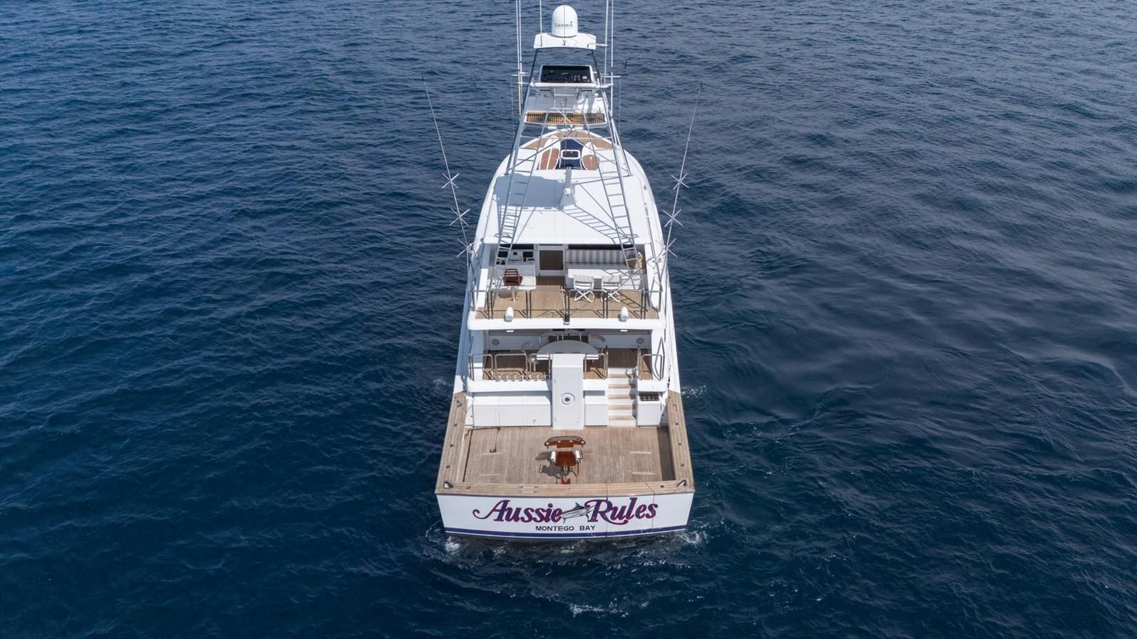 The yacht's aft deck is beautifully captured as it cruises on serene waters. aboard AUSSIE RULES Yacht for Sale
