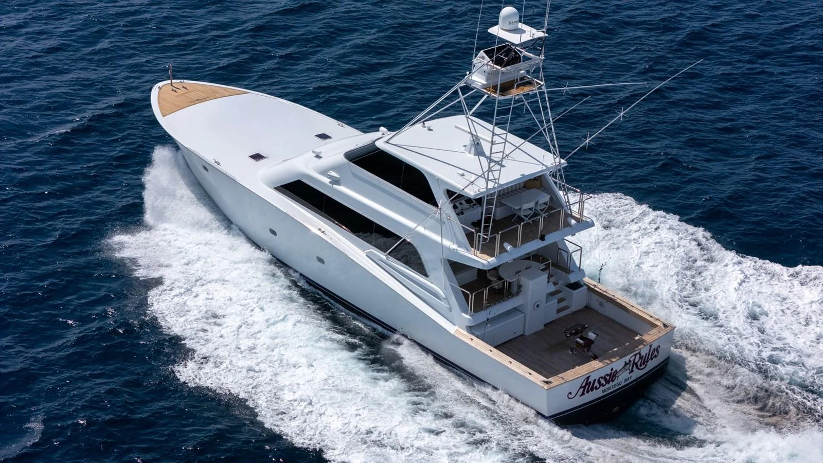 A sleek yacht cruises through the open water, showcasing its elegant design and powerful performance. aboard AUSSIE RULES Yacht for Sale