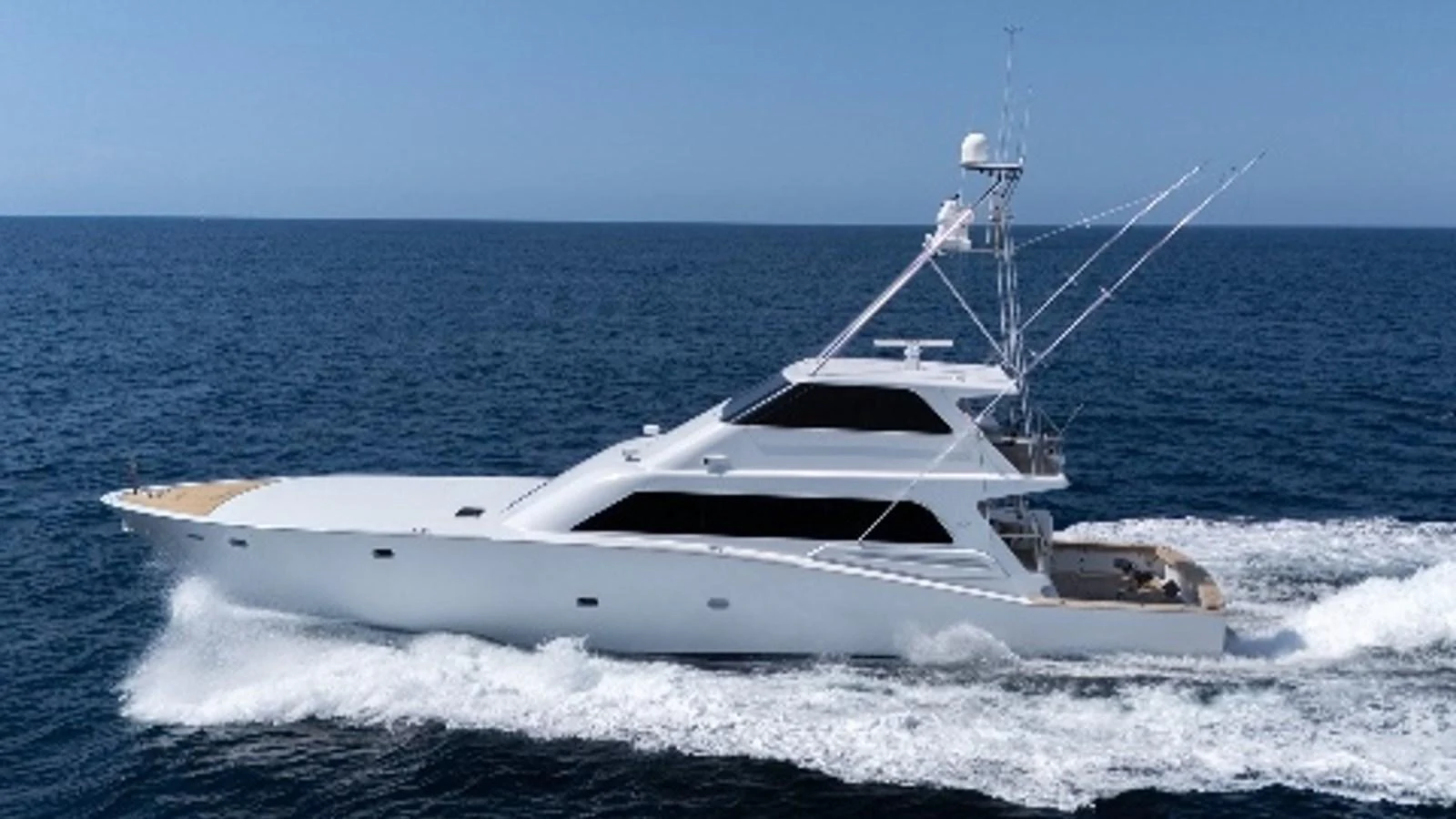 A sleek and modern yacht cruising swiftly on open waters under a clear blue sky. aboard AUSSIE RULES Yacht for Sale