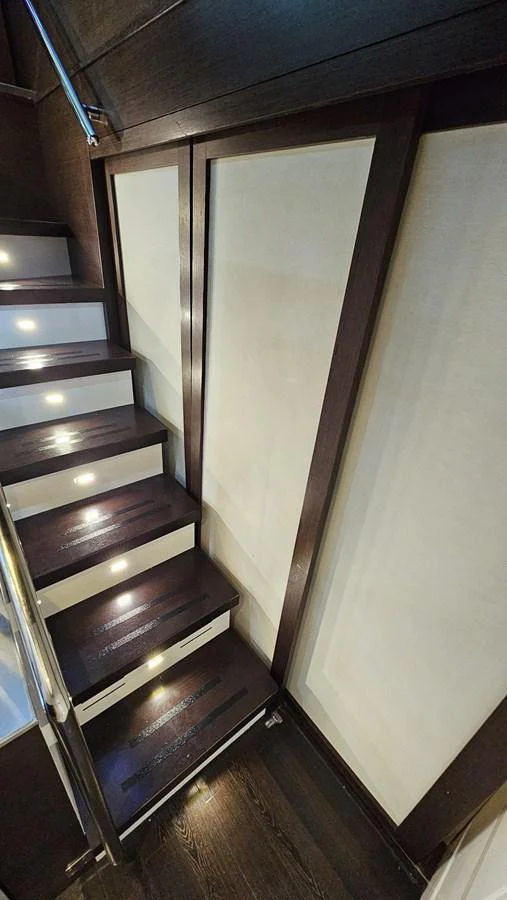 A sleek and modern staircase with ambient lighting enhances the yacht's interior elegance. aboard AMAR T Yacht for Sale