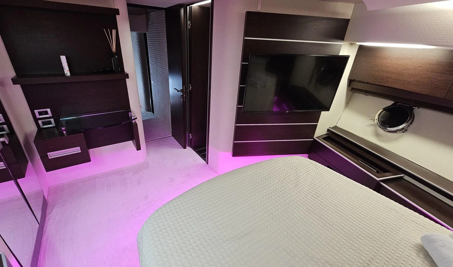 A modern stateroom featuring a large bed, ambient lighting, and a flat-screen TV. aboard AMAR T Yacht for Sale