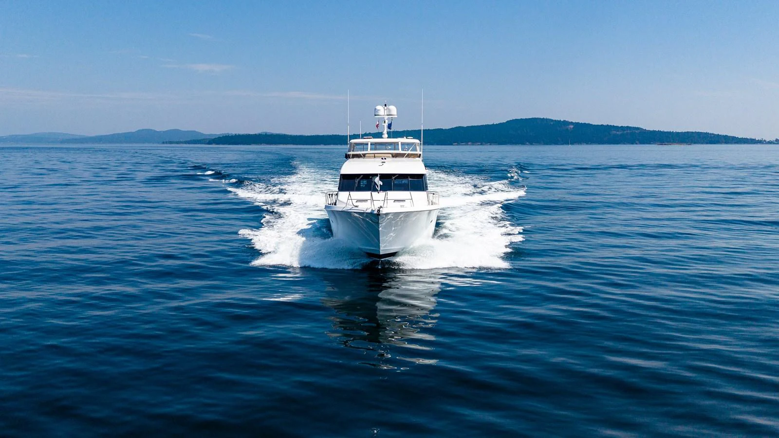 A sleek yacht cruises through calm waters, leaving a gentle wake behind. aboard DAWN TRADER VII Yacht for Sale