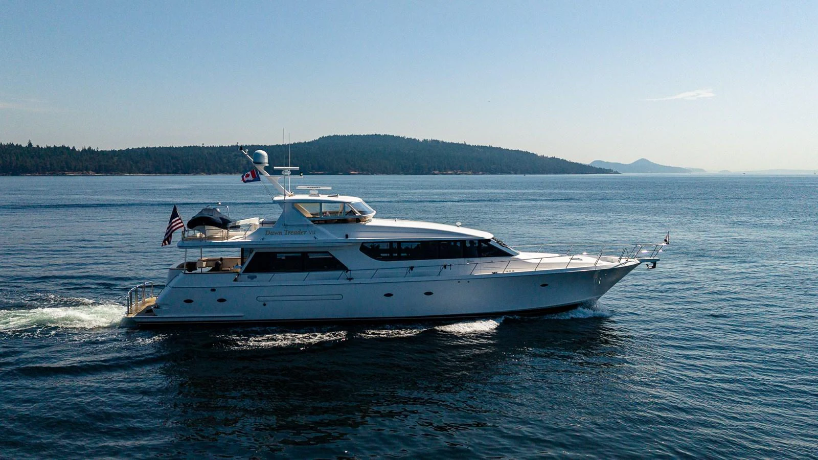 A sleek yacht cruises gracefully on calm waters with a scenic backdrop. aboard DAWN TRADER VII Yacht for Sale