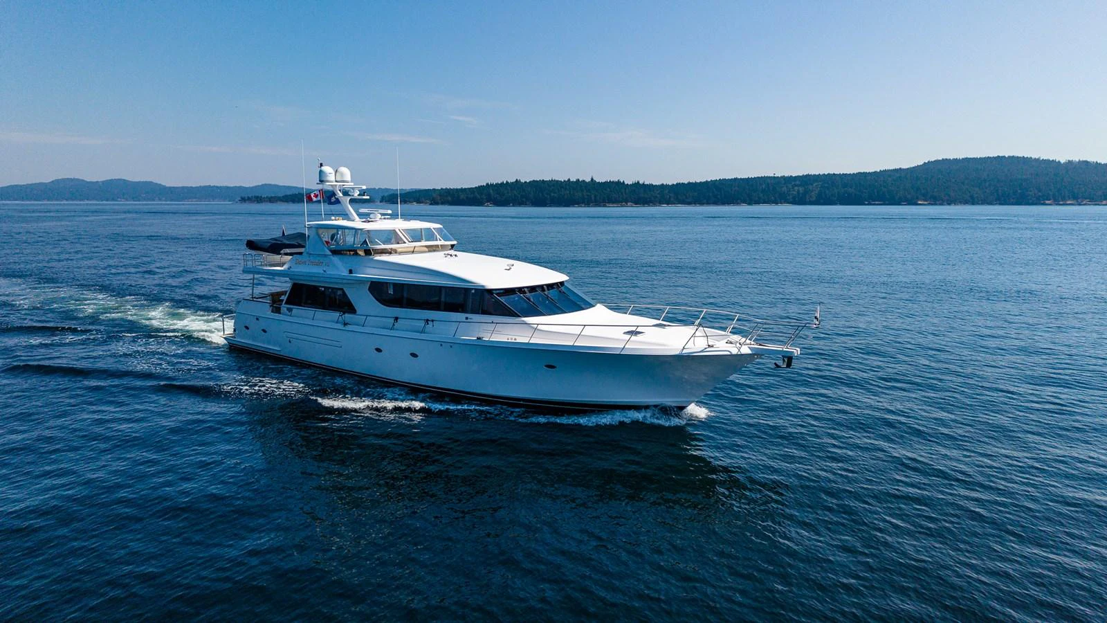 A sleek yacht cruises through calm waters on a clear day. aboard DAWN TRADER VII Yacht for Sale