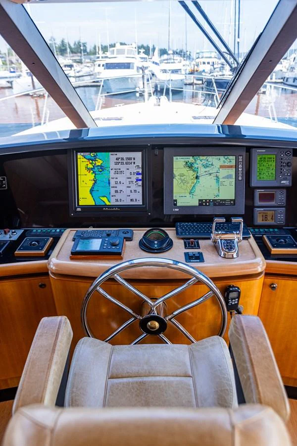 The helm station features advanced navigation equipment and a comfortable captain's chair. aboard DAWN TRADER VII Yacht for Sale