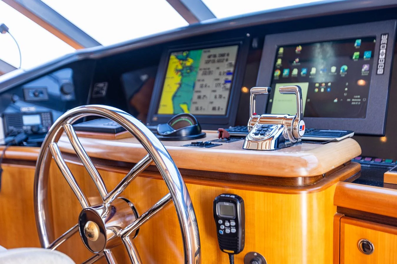 The helm station features advanced navigation equipment and a polished wooden steering wheel. aboard DAWN TRADER VII Yacht for Sale