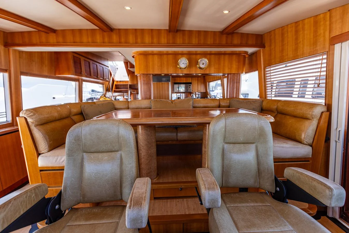 The yacht's interior features a cozy seating area with plush chairs and a wooden table, exuding warmth and comfort. aboard DAWN TRADER VII Yacht for Sale