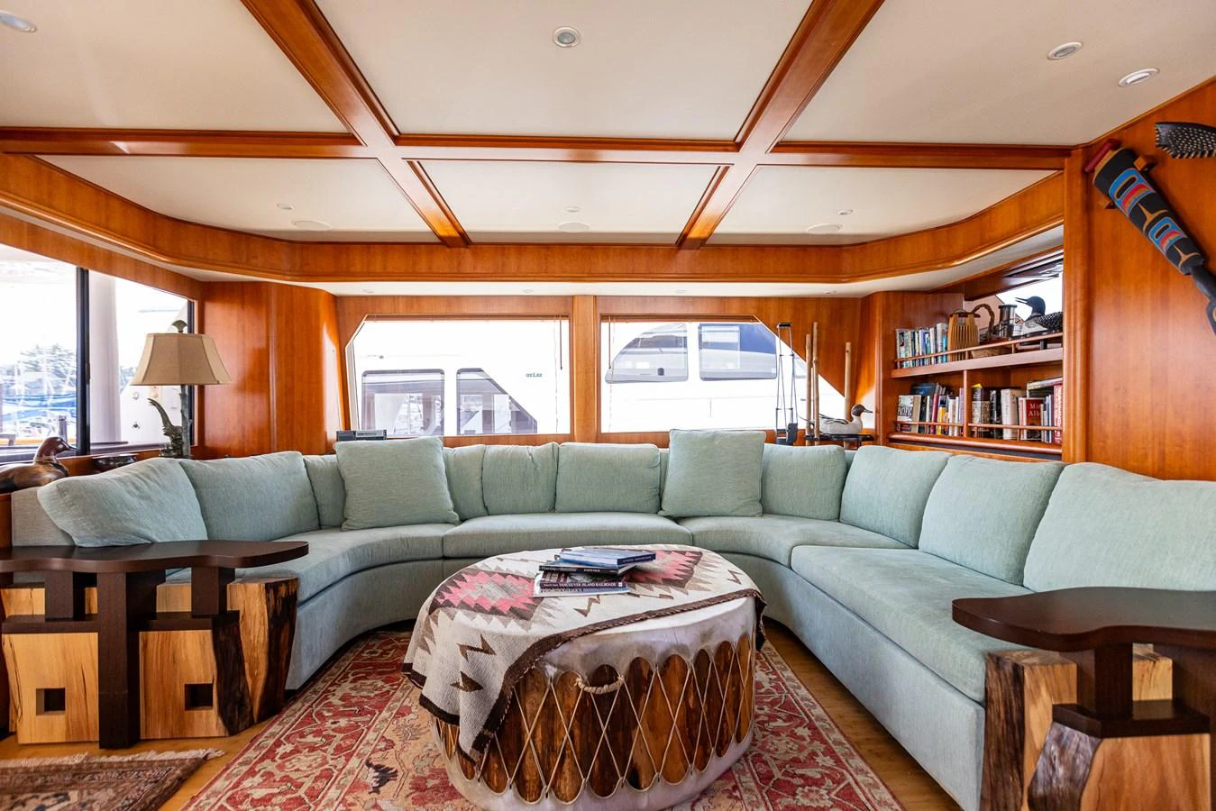 The salon features a spacious and inviting seating area with a large, curved sofa and elegant wooden accents. aboard DAWN TRADER VII Yacht for Sale