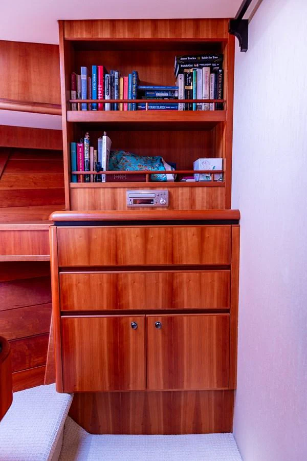 A cozy interior space featuring a wooden bookshelf and cabinetry, perfect for onboard relaxation. aboard DAWN TRADER VII Yacht for Sale