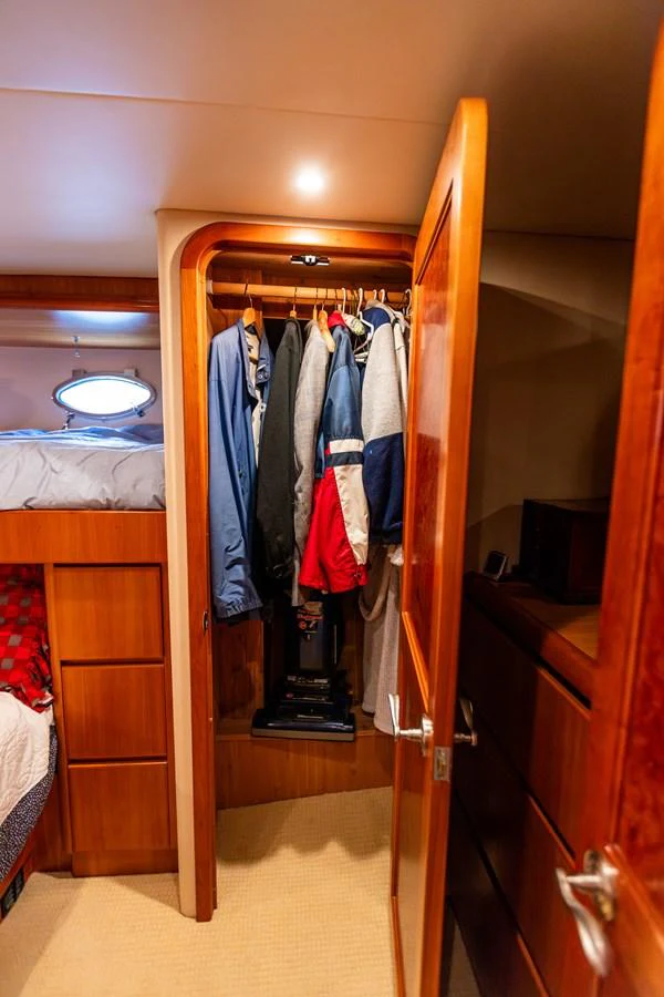A cozy yacht cabin with a wardrobe and neatly arranged clothes. aboard DAWN TRADER VII Yacht for Sale
