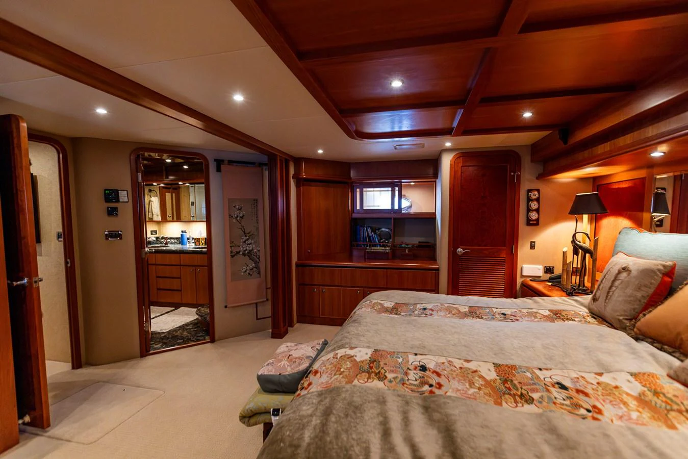 A luxurious stateroom featuring a large bed, warm wood finishes, and ambient lighting. aboard DAWN TRADER VII Yacht for Sale