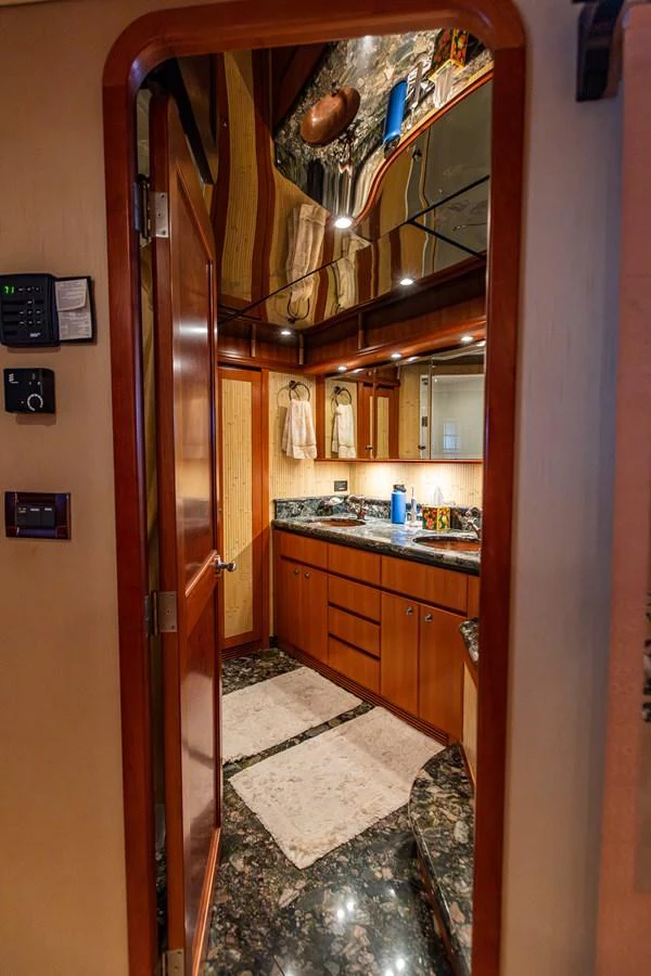 The yacht's bathroom features elegant wood cabinetry and a luxurious marble countertop. aboard DAWN TRADER VII Yacht for Sale