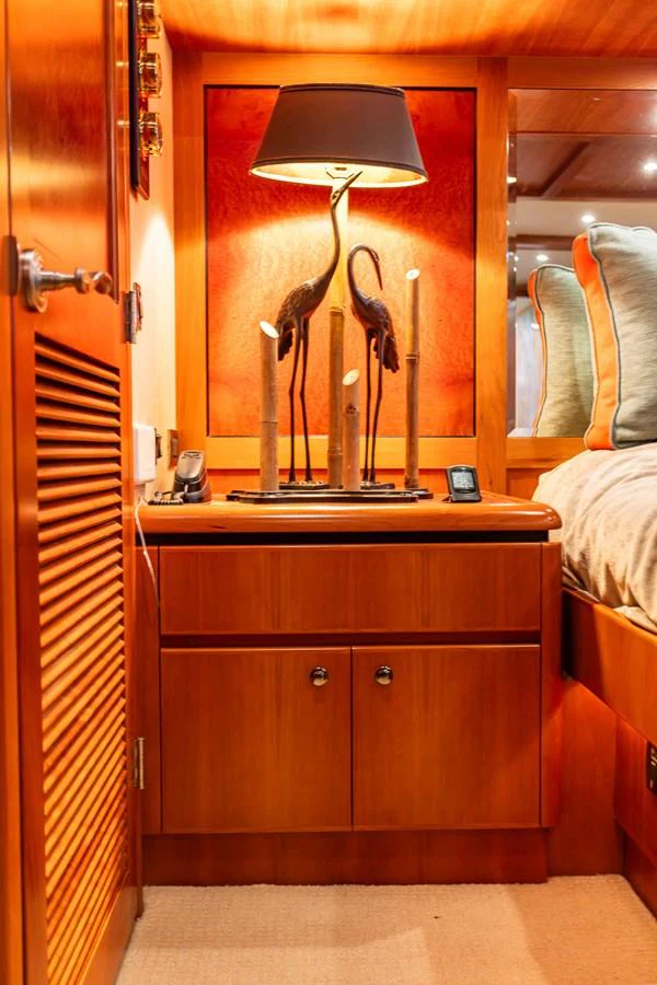 A cozy cabin corner featuring a bedside table with elegant decor and warm lighting. aboard DAWN TRADER VII Yacht for Sale