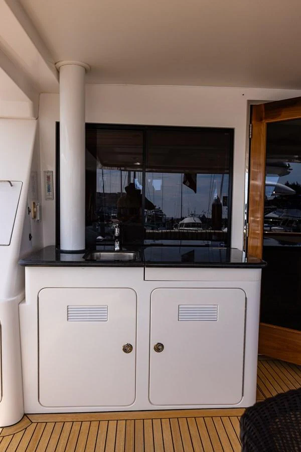 This image showcases a compact galley area with a sleek countertop and built-in storage. aboard DAWN TRADER VII Yacht for Sale