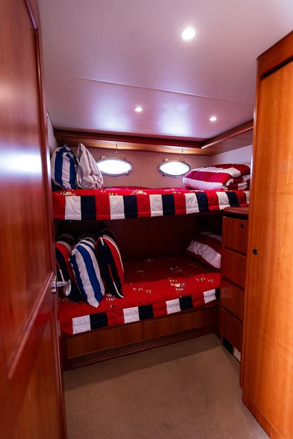 The cozy bunk cabin features vibrant bedding and warm wood finishes. aboard DAWN TRADER VII Yacht for Sale