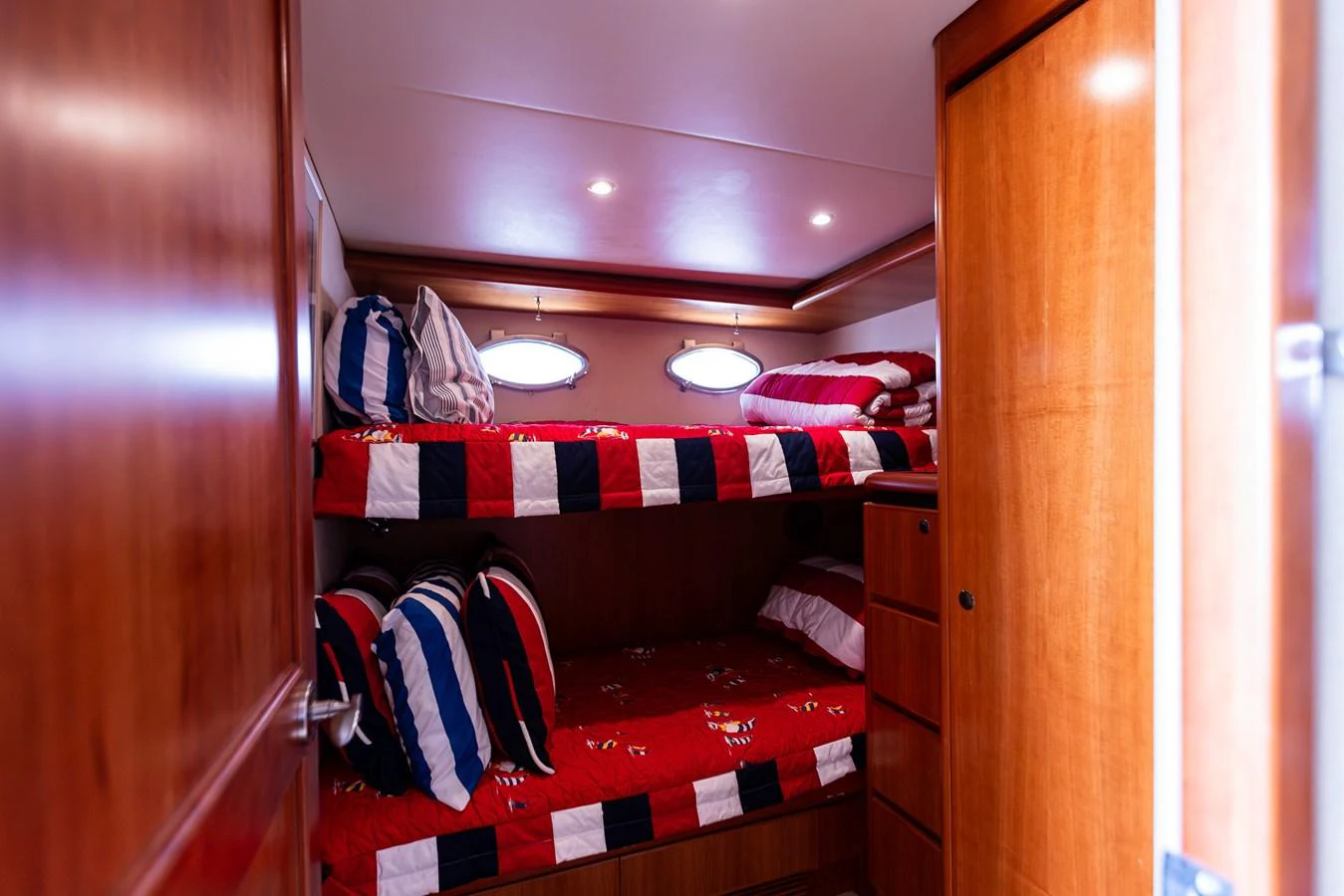 The cozy cabin features bunk beds with vibrant bedding and warm wooden finishes. aboard DAWN TRADER VII Yacht for Sale