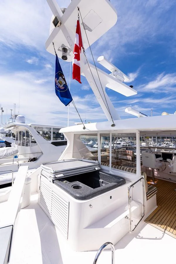 The flybridge features a compact outdoor kitchen area with a grill and sink, perfect for alfresco dining. aboard DAWN TRADER VII Yacht for Sale