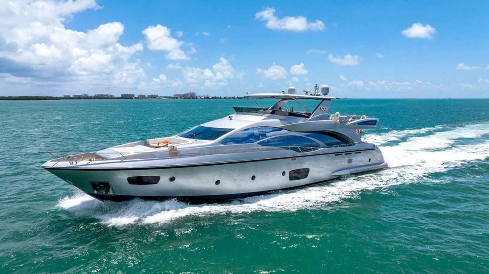 A sleek and modern yacht cruises through clear blue waters under a bright sky. aboard BEAUTIFUL M Yacht for Sale