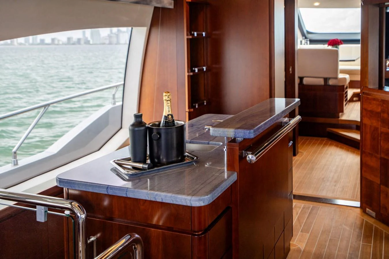 A luxurious yacht interior featuring a stylish bar area with a view of the water. aboard BEAUTIFUL M Yacht for Sale