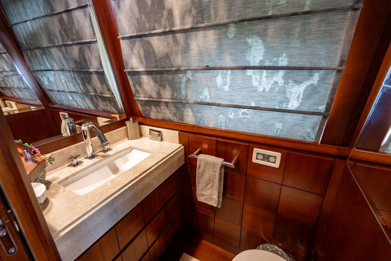 A well-appointed yacht bathroom featuring a sleek sink and elegant wooden cabinetry. aboard BEAUTIFUL M Yacht for Sale