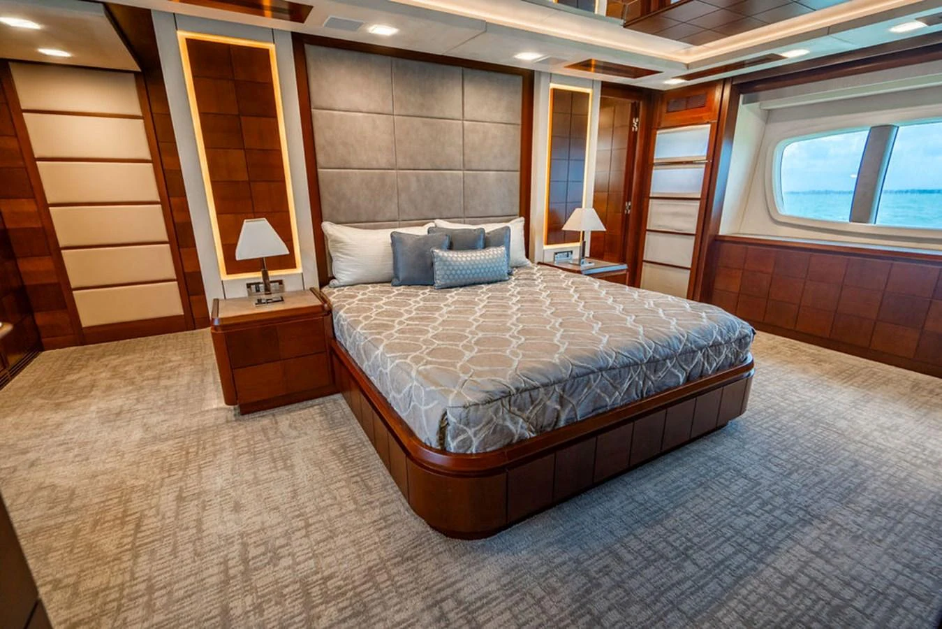 The master stateroom features a luxurious bed with elegant bedding and ample natural light from the large window. aboard BEAUTIFUL M Yacht for Sale