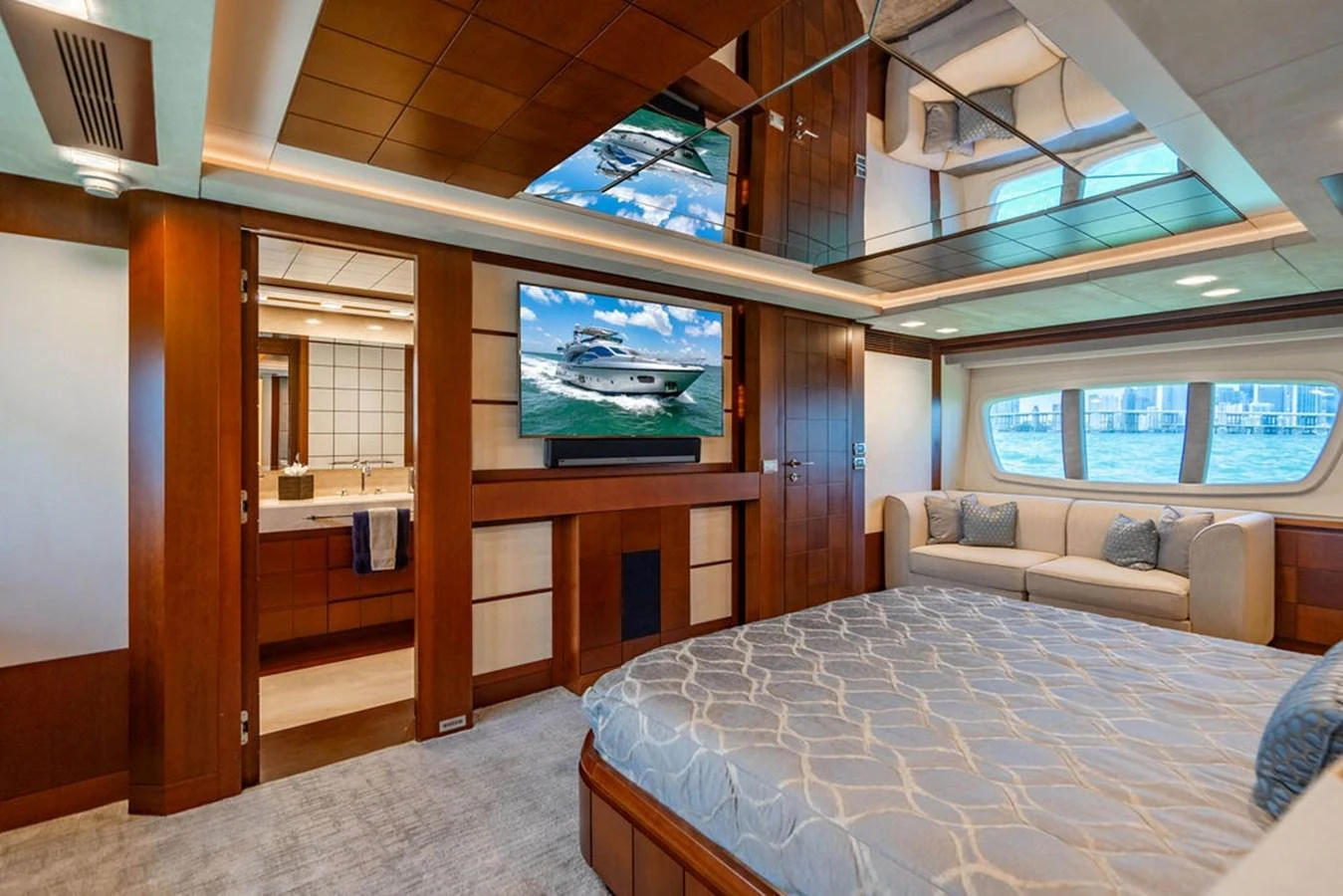 The master stateroom features a spacious layout with a large bed, a seating area, and a flat-screen TV. aboard BEAUTIFUL M Yacht for Sale