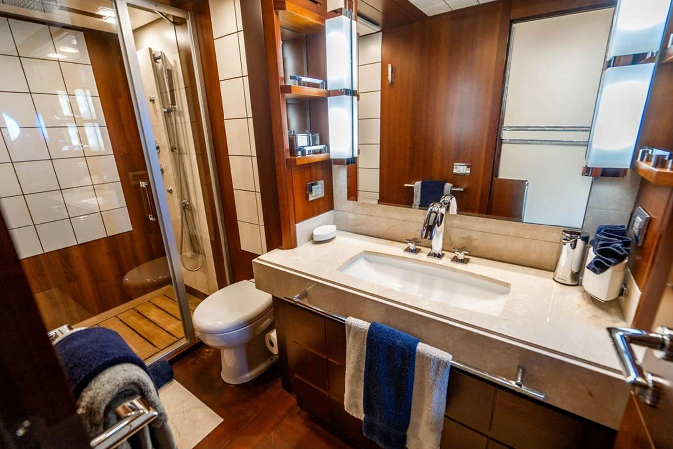 The yacht's bathroom features elegant wood paneling, a spacious shower, and modern fixtures. aboard BEAUTIFUL M Yacht for Sale