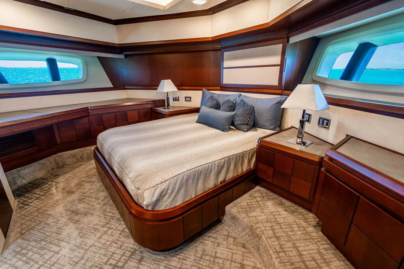 The master stateroom features a luxurious bed with elegant wood paneling and large windows offering stunning ocean views. aboard BEAUTIFUL M Yacht for Sale