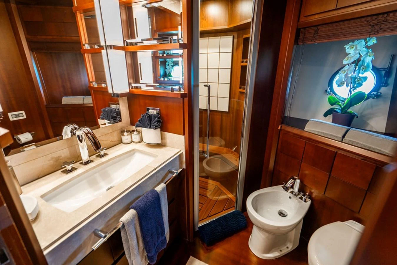 The yacht's bathroom features elegant wood finishes and modern fixtures. aboard BEAUTIFUL M Yacht for Sale