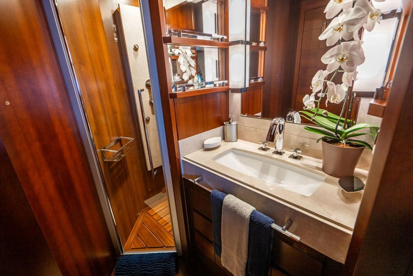 A luxurious yacht bathroom featuring elegant wood paneling and a stylish sink area. aboard BEAUTIFUL M Yacht for Sale