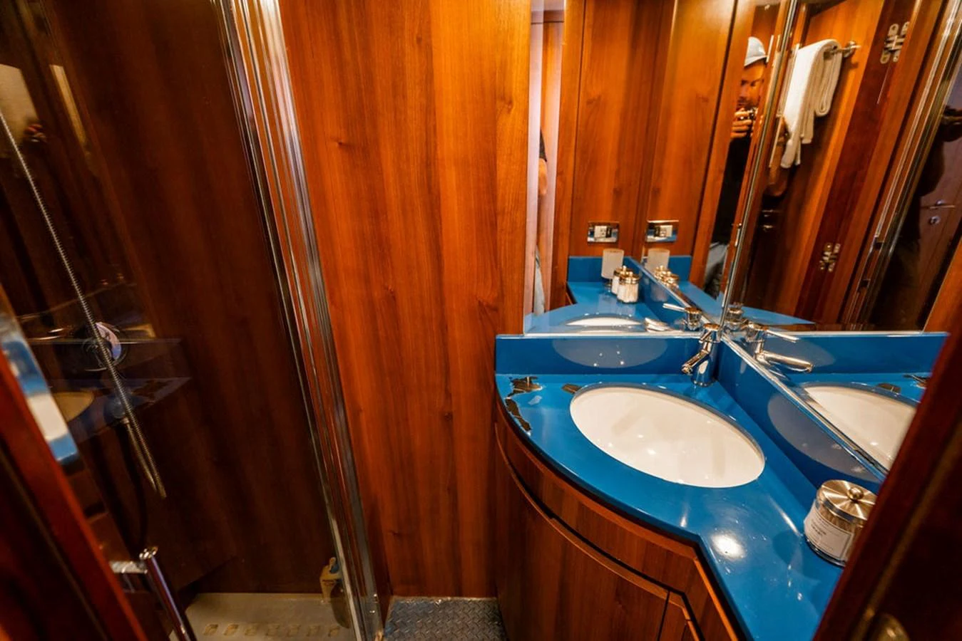 The yacht's bathroom features a sleek design with a vibrant blue countertop and wooden paneling. aboard BEAUTIFUL M Yacht for Sale