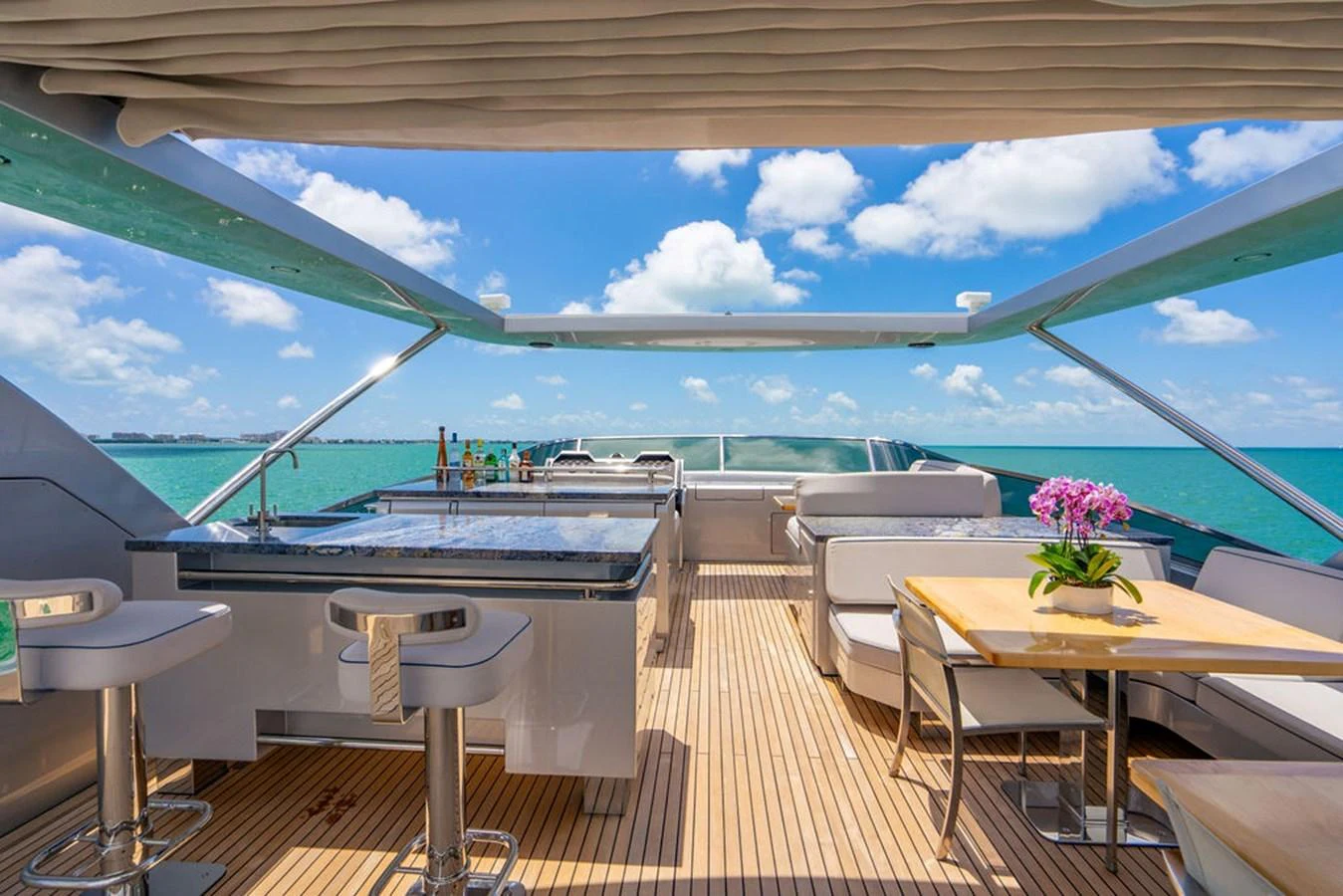 The sundeck offers a luxurious space with a bar, seating area, and stunning ocean views. aboard BEAUTIFUL M Yacht for Sale