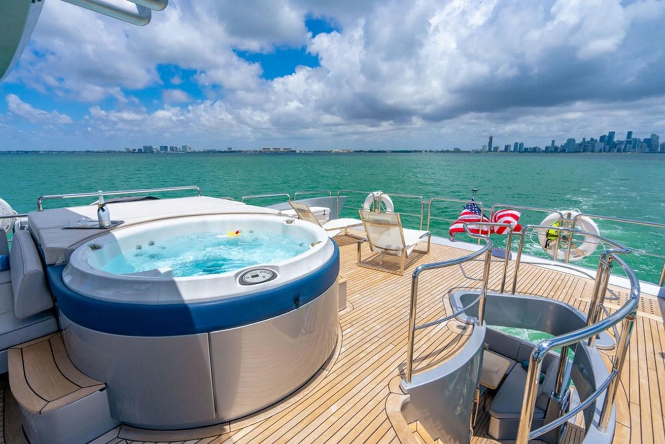 The aft deck features a luxurious hot tub with stunning views of the city skyline and ocean. aboard BEAUTIFUL M Yacht for Sale