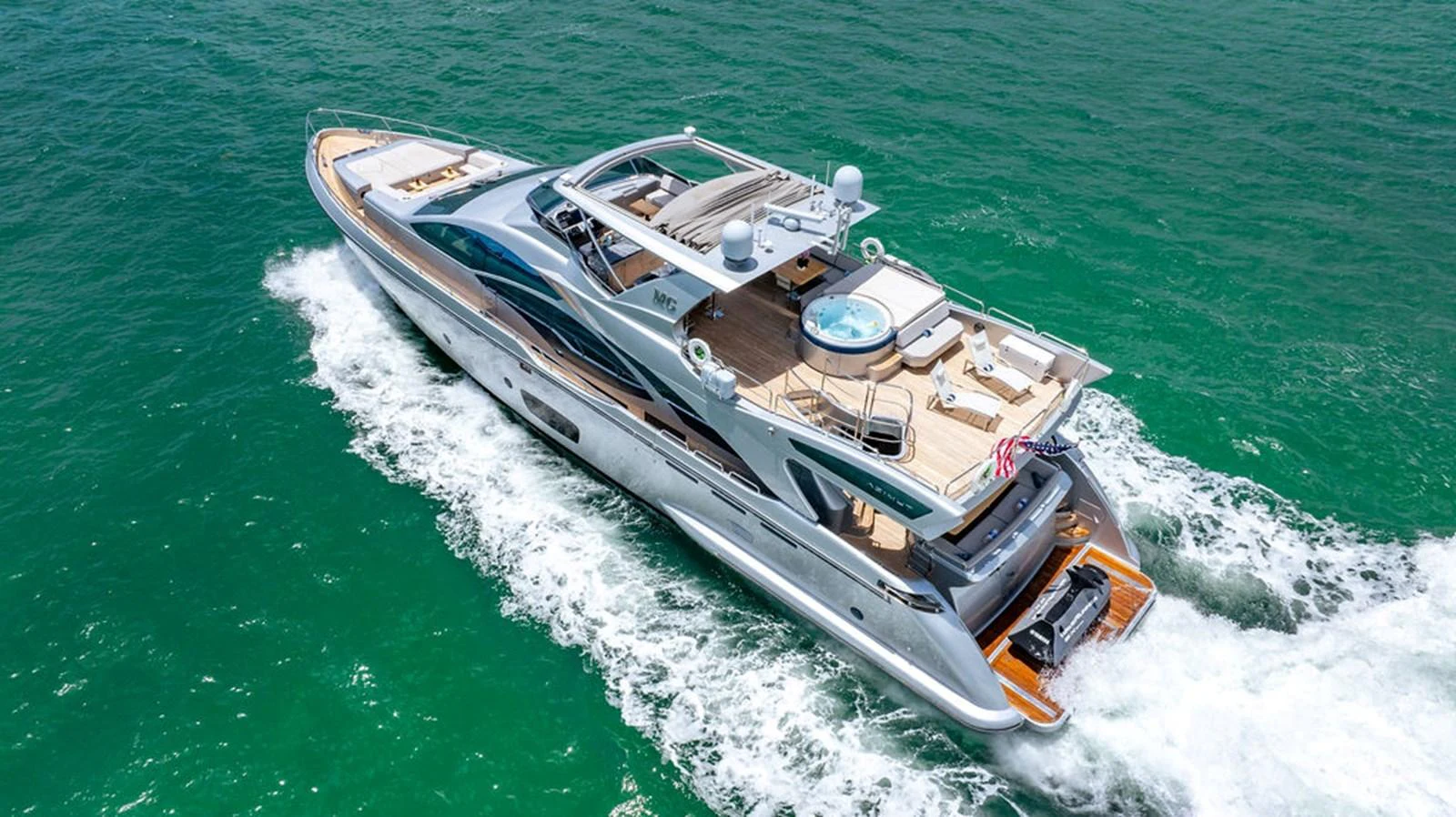 A sleek and modern yacht cruising through vibrant turquoise waters, showcasing its luxurious amenities and elegant design. aboard BEAUTIFUL M Yacht for Sale