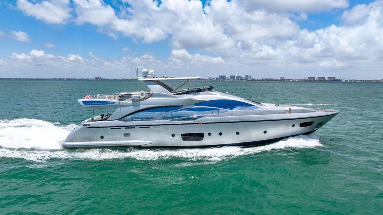 A sleek and modern yacht cruises through calm waters under a bright blue sky. aboard BEAUTIFUL M Yacht for Sale