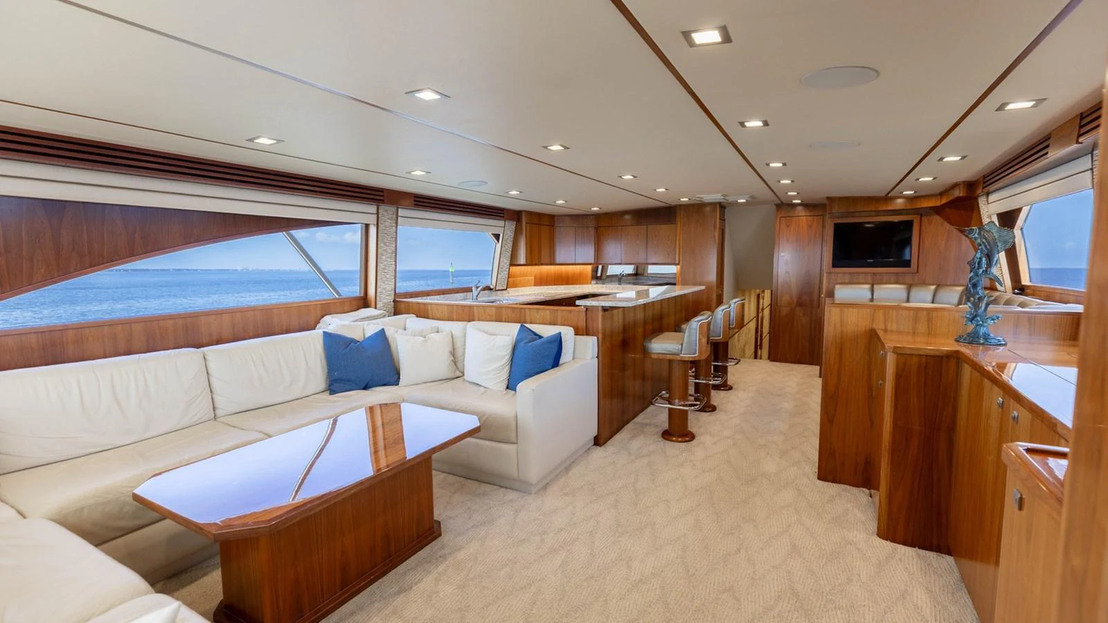 The salon features a spacious seating area with elegant wooden finishes and large windows offering stunning ocean views. aboard CE Yacht for Sale
