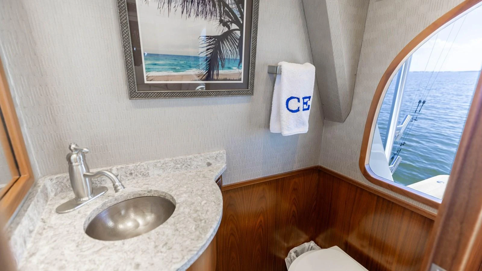A well-appointed yacht head with a sleek sink and a view of the sea. aboard CE Yacht for Sale
